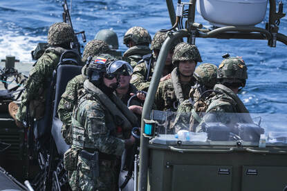 Close-up van Nederlandse en Colombiaanse mariniers aan boord van een FRISC-onderscheppingsboot.