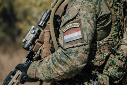 Schouder militair met daarop een Nederlandse vlag met daarboven de tekst ‘Korps Mariniers’.