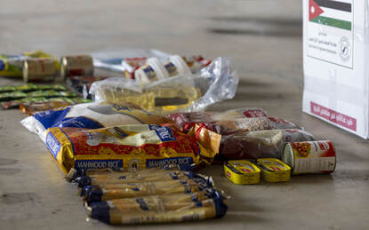 Links een foto van een ingepakte parachute op een bundel. Rechts wat voedselitems die in een noodpakket zitten.