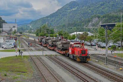een trein beladen met Leclerc gevechtstanks rijdt tussen de Alpen door.