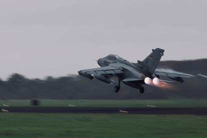 Een straaljager komt net los van de grond.