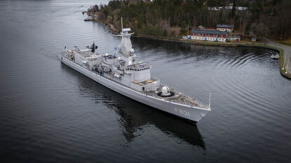 Fregat vaart door inham.