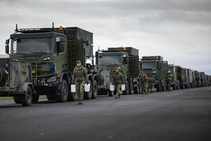 Twee foto’s waarop militairen bezig zijn met beladen van de colonne met legervrachtwagens.
