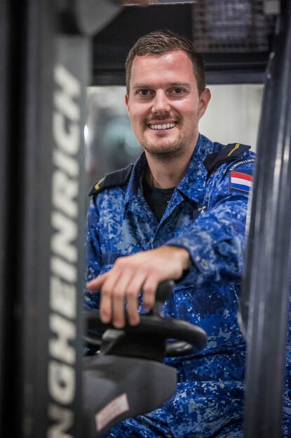 Portret van Matroos 1 LDGB Dennis in een heftruck.