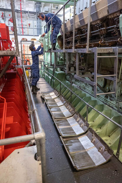 Matroos 2 Hidde pakt een metalen kap aan van een collega.