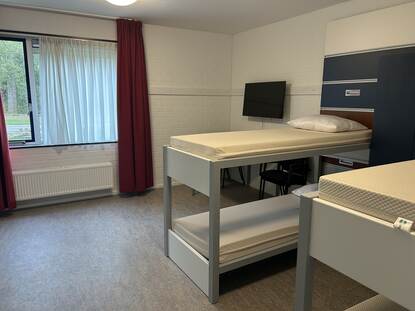 2 stapelbedden, een TV, ramen en een gordijn.