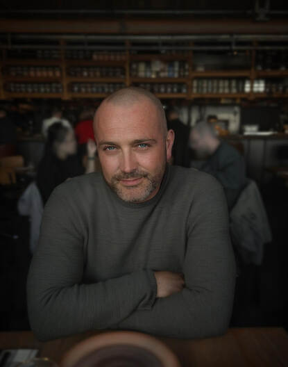 Kevin Nijman, met armen over elkaar aan tafel.