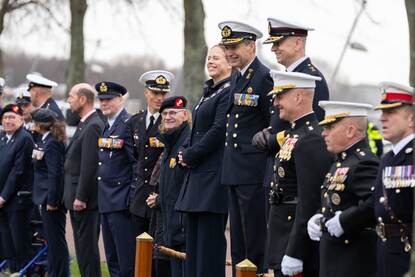 Links legt de Rotterdamse burgemeester Carola Schouten legt een krans bij ‘De Marinier’ en rechts een opname van Commandant Zeestrijdkrachten vice-admiraal Harold Liebregs die – geflankeerd door collega’s en buitenlandse hoogwaardigheidsbekleders – het defilé afneemt.