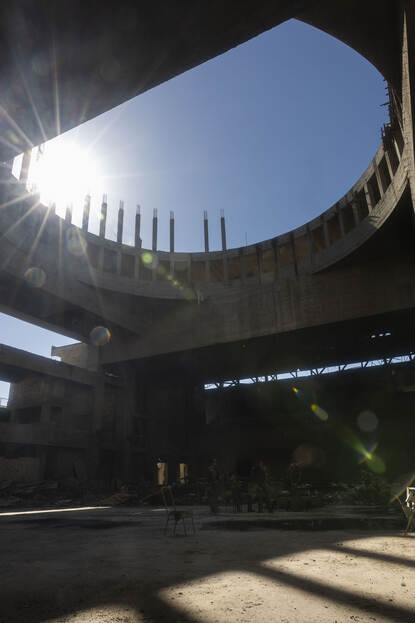 Zon schijnt door een grote ronde opening in het dak van een gebouw.