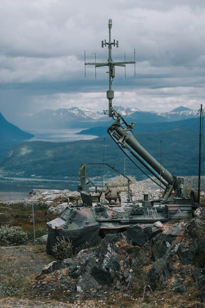 Een militair loopt met een karretje bij het onbemande verkenningsysteem.