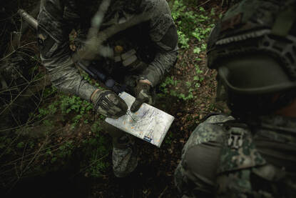 Een voertuigcontrole en een kaartlezende militair.