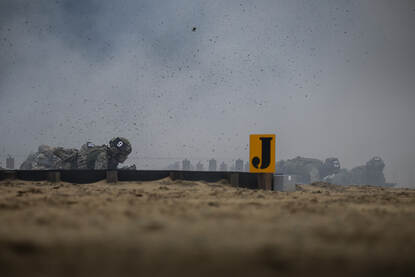tijgerende militairen en opspattend zand.