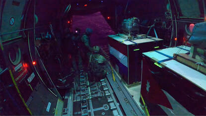 Nederlandse militairen met bundels hulpgoederen in de C-130 vlak voordat er gedropt gaat worden.