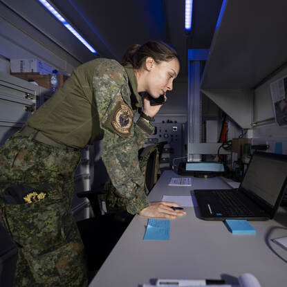 Eerste luitenant Danique staat met een telefoon aan haar oor.