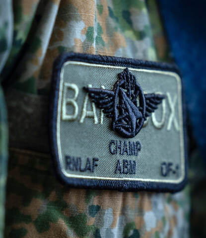 Een badge met daarom het callsign ‘Champ’. Daaronder de afkortingen RNLF en ABM.