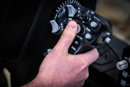 Een vlieger met een VR-bril op zij hoofd kijkt opzij. Daarnaast een foto van de stick die hij in zijn handen heeft.