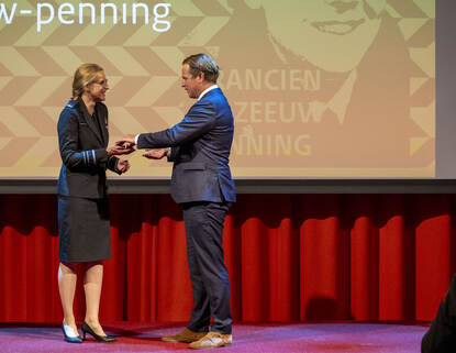 Luitenant-generaal Elanor Boekholt-O’Sullivan neemt de penning in ontvangst uit handen van staatssecretaris Gijs Tuinman.