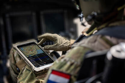 Vlieger zittend in cockpit met tablet op de been bevestigd.