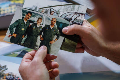 Arthur met collega’s poserend voor een Alouette III en zittend erin.