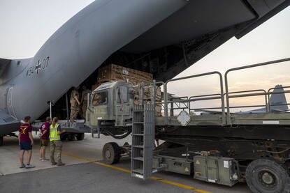 Links wordt vracht in een Duitse A400M geschoven en rechts rijdt een heftruck over het platform.