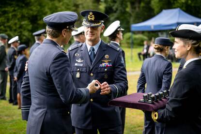 De Smit reikt aan een luchtmachter het embleem uit.