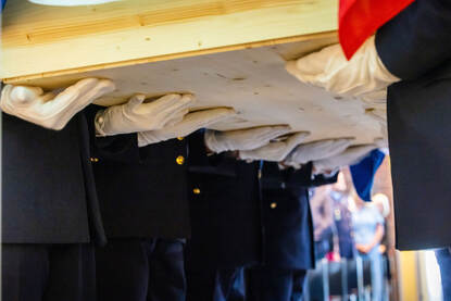 De draagploeg in het dagelijks tenue tijdens diverse uitvaarten. Daarbij zijn ze zowel te zien met de kist op hun schouders als saluerend naast de kist.