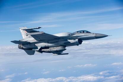 Links een vliegende Nederlandse F-35, rechts een Poolse F-16.