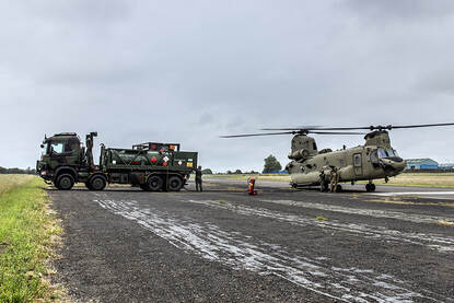 Afbeeldingen van een Chinook, een NH90, een MQ-9 Reaper en twee F-35’s die over een marineschip vliegen.