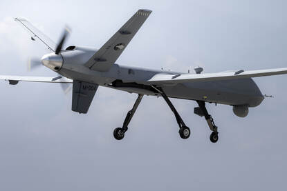 Afbeeldingen van een Chinook, een NH90, een MQ-9 Reaper en twee F-35’s die over een marineschip vliegen