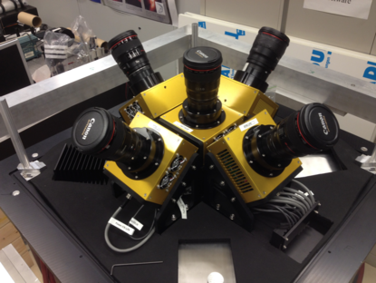 Op een halve ronding vijf gele blokjes met op ieder een lange cameralens, ze hebben dus ieder een ander perspectief.