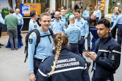 Medewerkers van de Koninklijke Marechaussee met elkaar in gesprek.