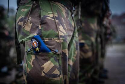Blauwe baret van de Marechaussee in een groene, militaire broek.
