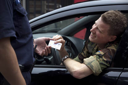 Een militair aan de poort laat zijn Defensiepas zien aan de wacht.