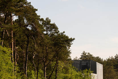 Bomen met daartussen een stukje gevel van een datacenter.