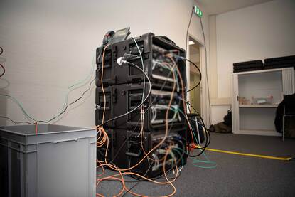 Drie flight cases met netwerk- en serverapparatuur.