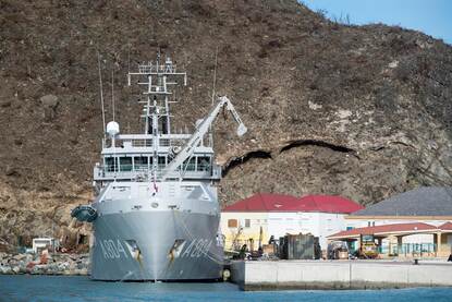 Twee foto’s van de Pelikaan tijdens het lossen van hulpgoederen in een haven.